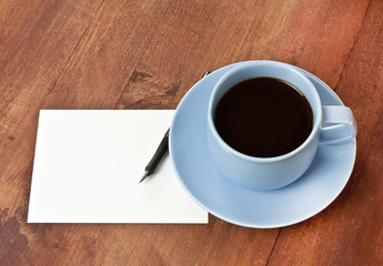 Cup of coffee with ink pen and blank post card