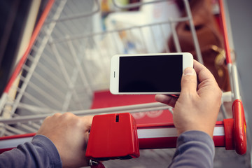 Close up on hands of man reading a text message during shopping
