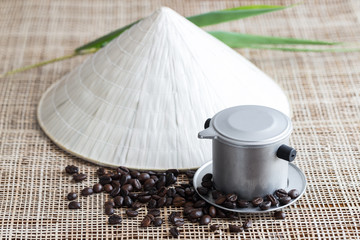 Vietnamese coffee brewing pot with coffee beans