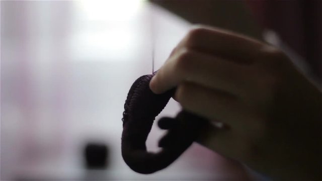 Slow motion of hands sewing ornaments