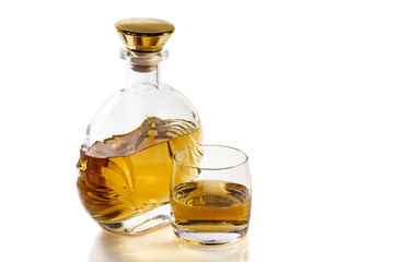 Bottle and glass of whiskey on white background