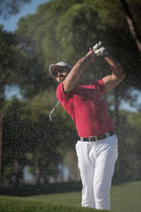 golfer hitting a sand bunker shot