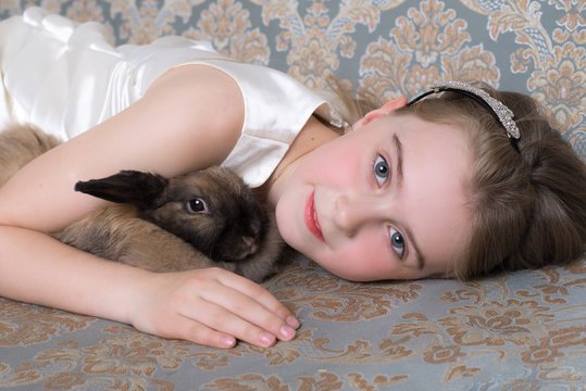 Ребенок девочка обнимает кролика 