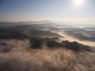 Naklejka na ściany i meble Aerial view of misty hills