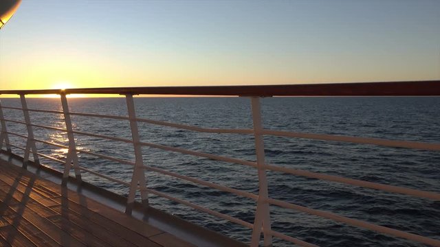Cruise ship deck and railing at sunset