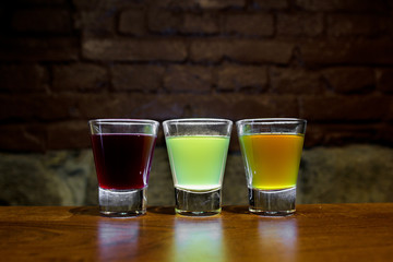 Tree colored shots on the bar.