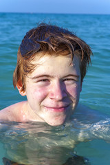 boy with red hair is enjoyingthe ocean