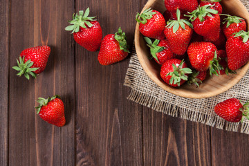 Fresh strawberries on an old wooden surface.