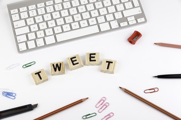 Text: TWEET from wooden letters on white office desk