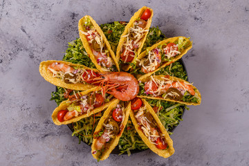 Tacos with shrimp, lettuce, cheese and jalapeno.