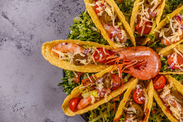 Tacos with shrimp, lettuce, cheese and jalapeno.