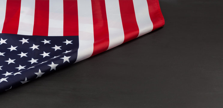 Folded American flag on black chalkboard with copy space