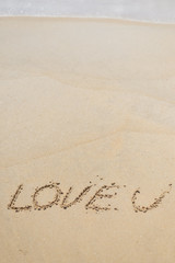LOVE U sign on wet sand beach background 
