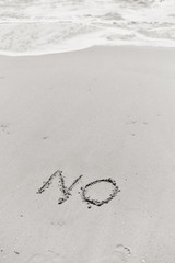 NO sign written in sand on beach texture sunny background. 