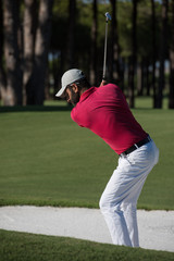 golfer hitting a sand bunker shot