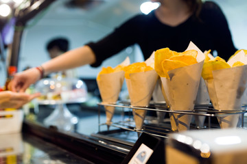 Young woman serving to a costumer in a food truck.