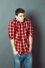 smiling reserved young man shrugging for shyness and shame