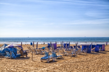 Der traumhafte Strand bei Agadir in Marokko mit leuchtenblauem Himmel und blauen Strandliegen am...
