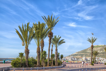 Auf der Strandpromenade der afrikanischen Hafenstadt Agadir in Marokko mit Blick auf die Kasbah - obrazy, fototapety, plakaty
