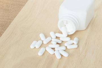 Fototapeta na wymiar many white pills / tablets / medicine on wood plate