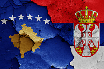 flags of Kosovo and Serbia painted on cracked wall