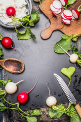 Fototapeta na wymiar Radishes preparation ingredients. Food background with fresh garden colorful Radishes , wooden spoon, kitchen knife, old cutting board and fresh cheese, top view