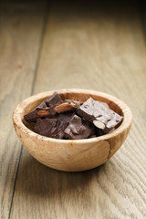 homemade chocolate with almonds in wood bowl, on wood table