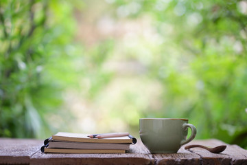 Notebook with pencil and cup on wooden table