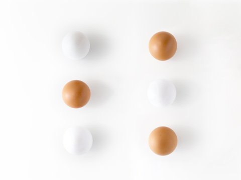 Top view of three white eggs and three brown eggs isolated on white