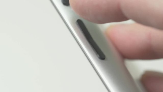 Side view of a tablet. Volume buttons being pressed.