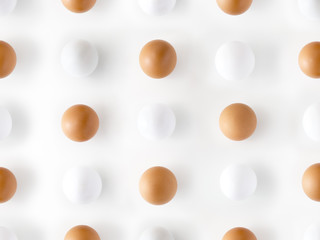 Top view of white eggs with brown eggs forming dots isolated on white