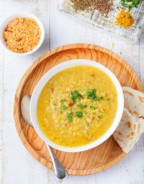 Lentil soup with bread in a ceramic white bowl on a wooden background Top view.