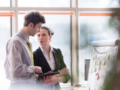 Young Couple Working On Flip Board At Office