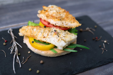 Fish grilled with tomato, pepper, green onion on the bread on th