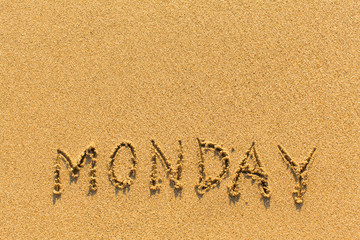 Monday - inscription by hand on a light-golden beach sand.
