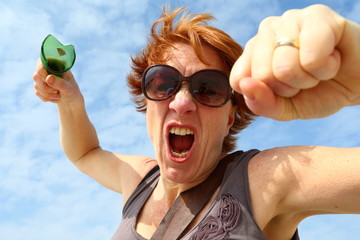 agressive/ woman with broken beer bottle in het hand threatening and shouting