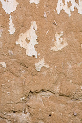 Cracked white paint on a wall of clay. Grunge wall of the old house, textured background