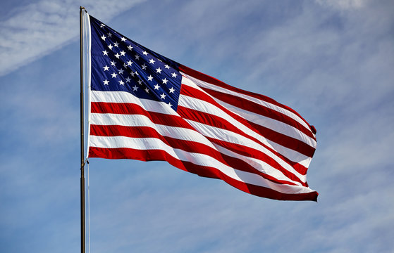 Flag USA in wind on flagpole with sky