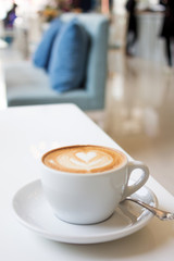 white cups of Cappuccino coffee with froth heart shaped on table
