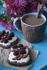 Sandwiches with sweet cheese and berries, a cup of coffee 