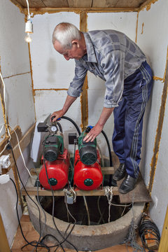  peasant makes adjustment of pumps in the pumping station room.