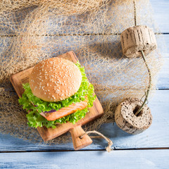 Homemade burger with fish and vegetables on fishing net