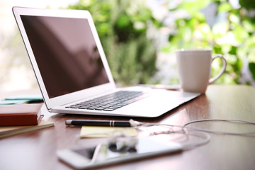Female hands working with a laptop outdoor on blurred green plant background