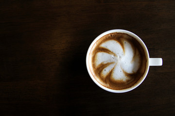 Cup of cappuccino art coffee with froth shape plumeria and woode