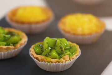 Fresh homemade fruit tarts with citruses and kiwi