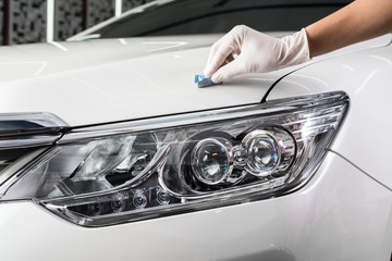 Car detailing series : Closeup of hand coating white car bonnet