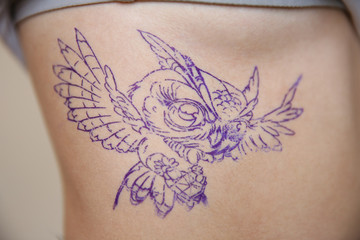 Female body with bird drawing, closeup