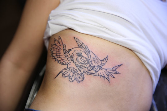 Female body with bird tattoo, closeup