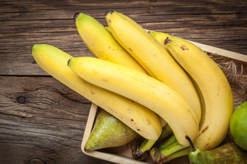 Bananas and other fruits in a wooden box.