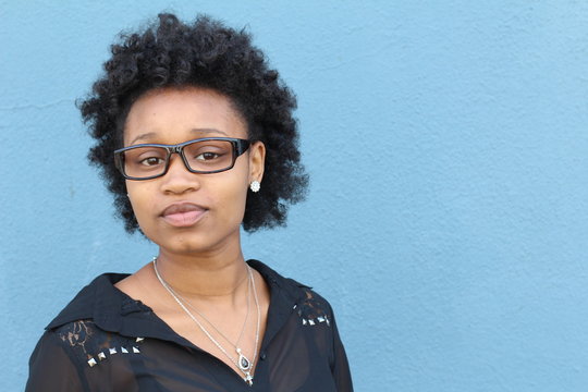 Portrait of smiling young african woman with afro and glasses. Copy space on the left side of the image